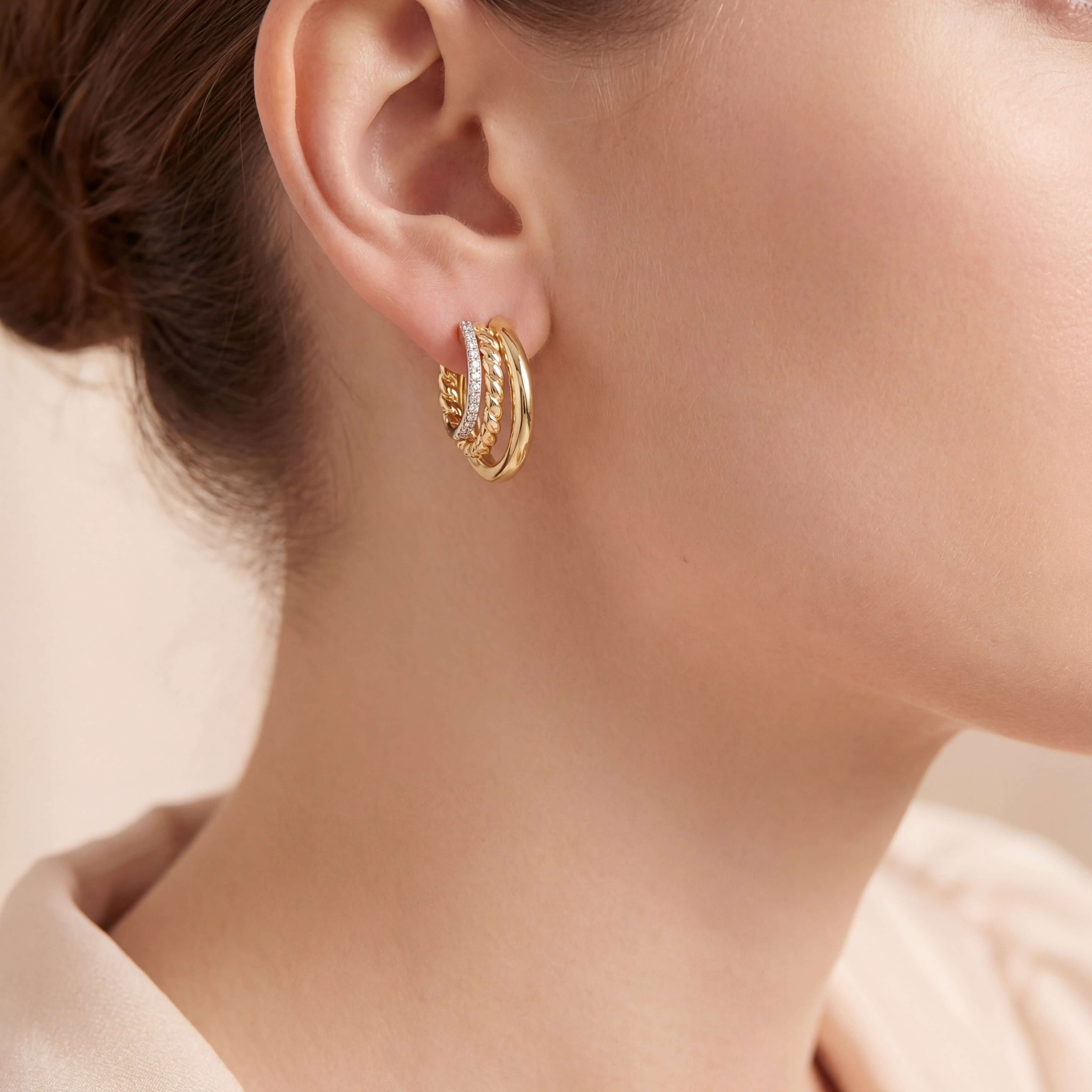 Close-up of a model wearing Graduated Triple Hoop Diamond Earrings in 14k gold, showcasing elegant design.