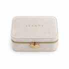 A rectangular ivory velvet jewelry box with gold zipper and heart-shaped metal charms, featuring the brand name 'IZAKOV' in gold on the lid, set against a plain white background.