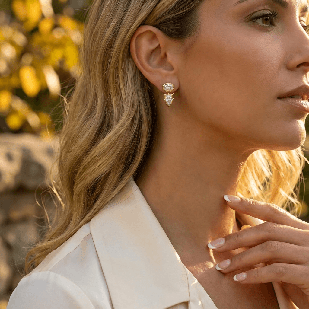 Woman wearing Oval and Pear Lab Diamond Star-Set Drop Earrings outdoors, showcasing elegance and sparkle.