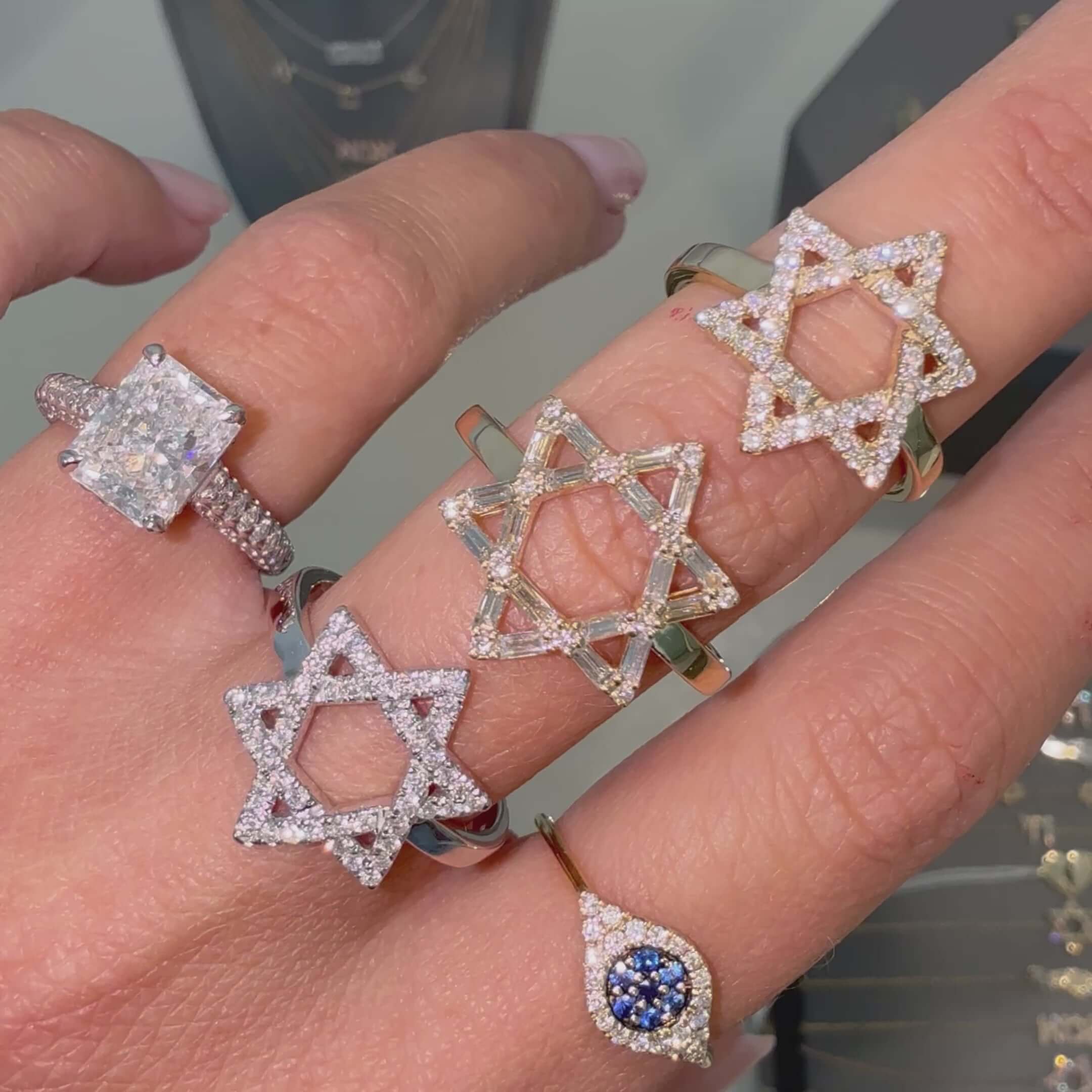 A collection of rings featuring the 14K Gold Star Of David Baguette Diamond Ring among other diamond-studded star rings.