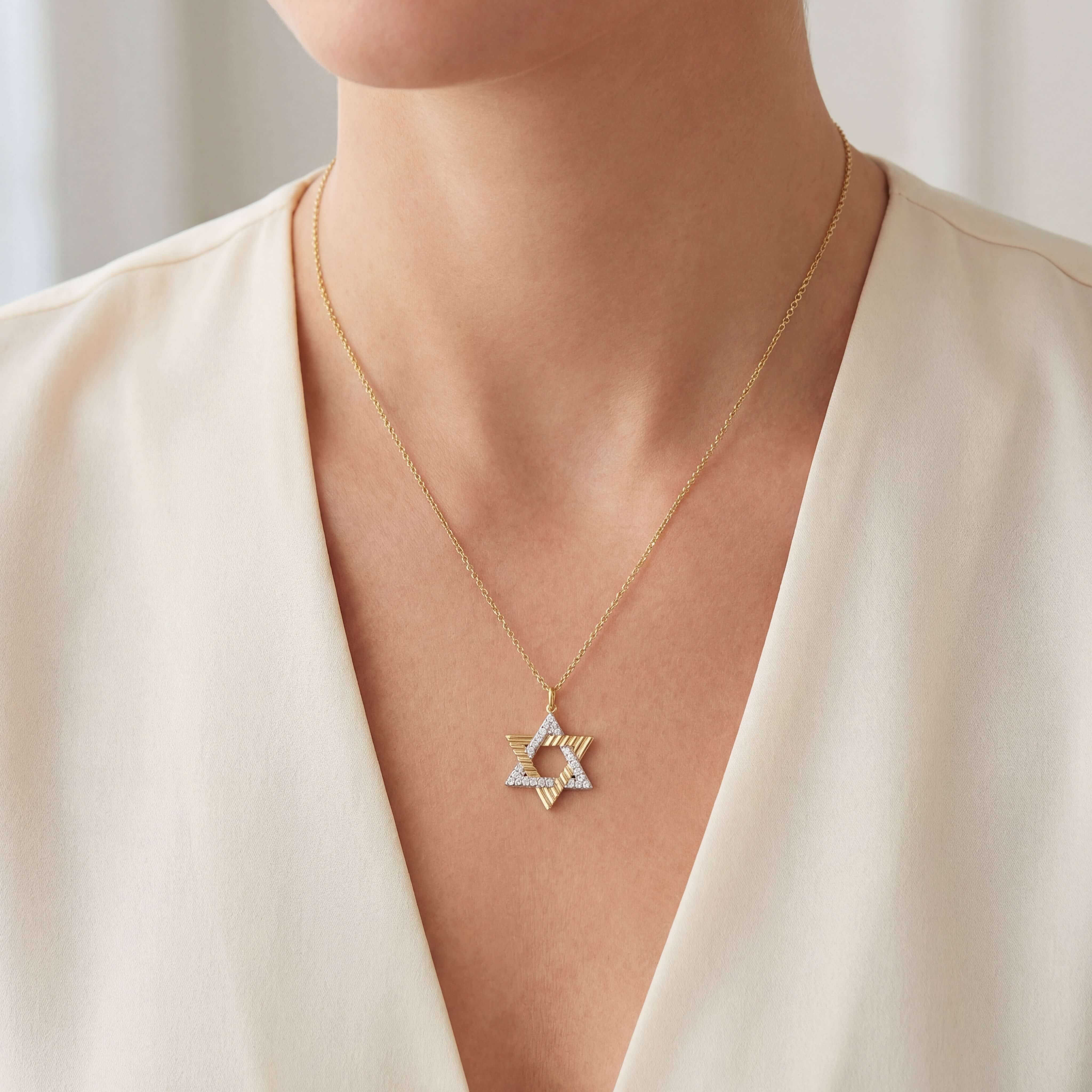 Radiating Star of David Diamond Pendant worn by a model, showcasing its 14k gold and diamond details.