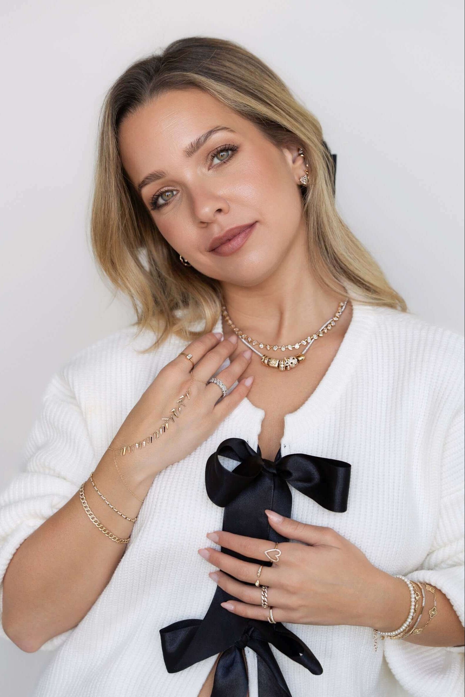Woman wearing 14k gold jewelry from Izakov Fine Jewelry in Miami, showcasing stylish pieces and elegant accessories.