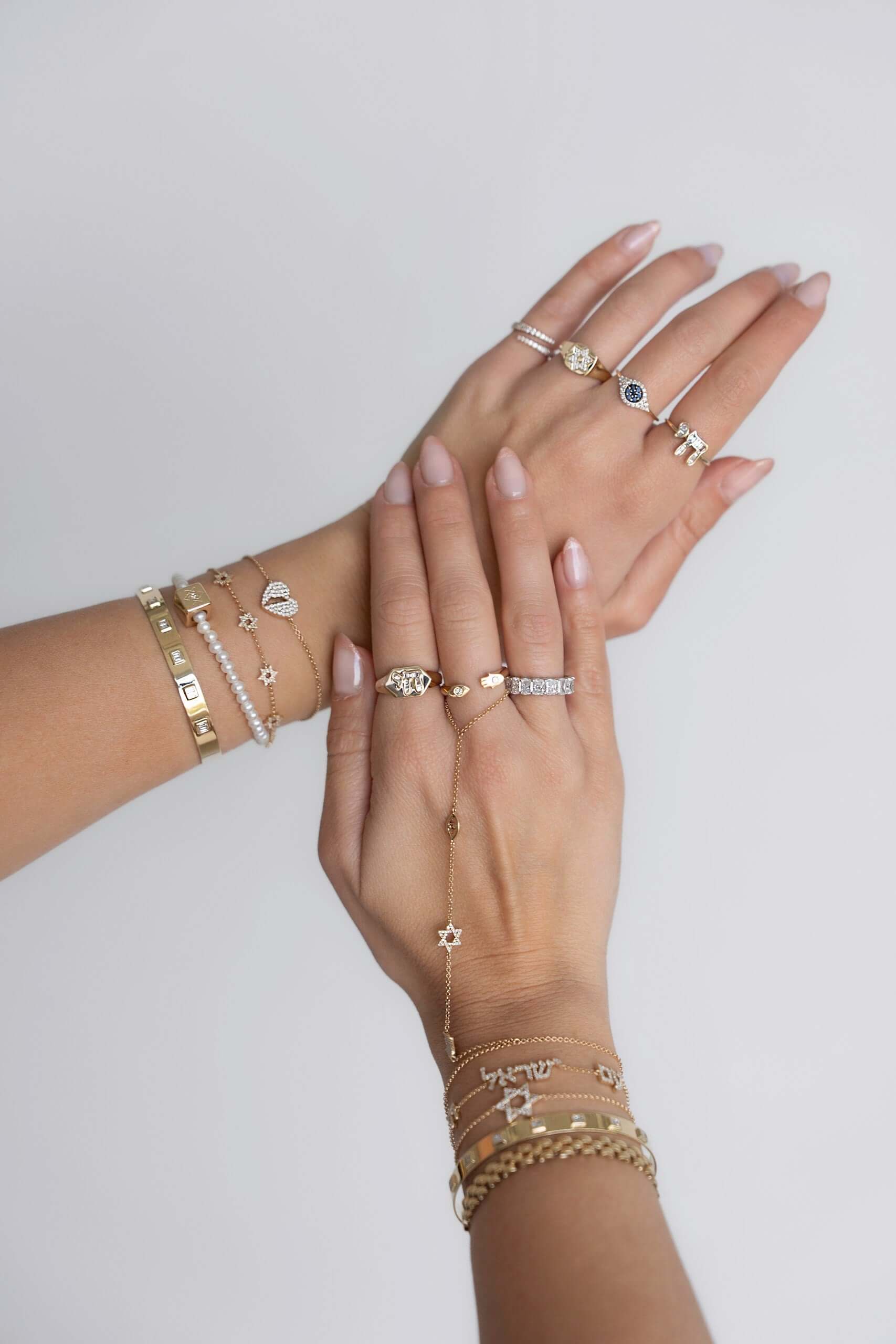 Elegant 14k gold jewelry collection by Izakov Fine Jewelry showcased on hands, located in Miami, Florida.