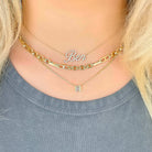Floating Bezel Asscher Cut Diamond Necklace layered with gold chains and a personalized nameplate 'Ben'.